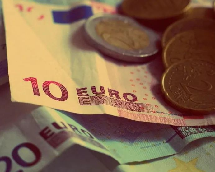 Billetes de euro y monedas apilados sobre una mesa
